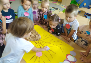 Dzieci wykonują pracę plastyczną "Kropkowe drzewo"